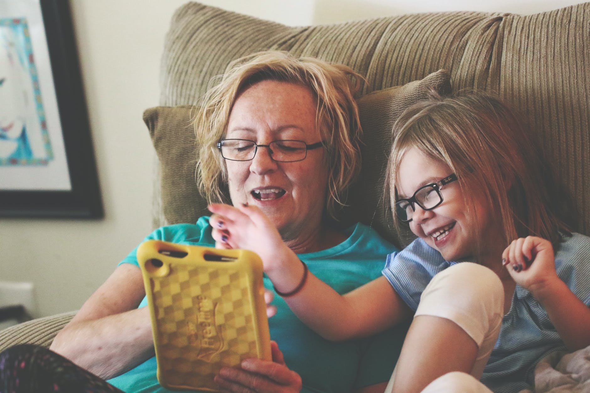 Avó e neta felizes jogando em um tablet