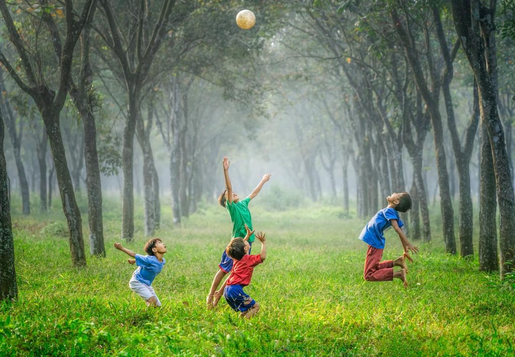 Crianças brincando em uma clareira verde