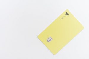 cartão de crédito amarelo, na diagonal, sobre fundo branco.
